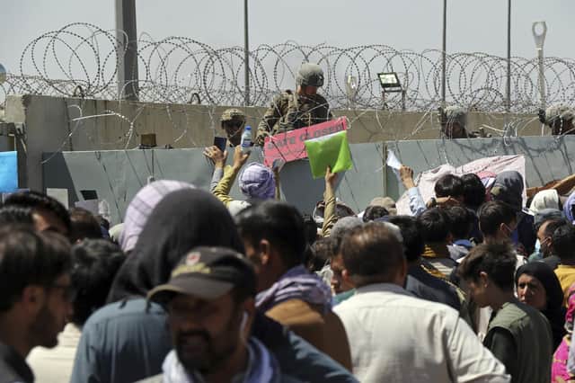 Hundreds of people gathering near an evacuation control checkpoint on the perimeter of the Hamid Karzai International Airport, in Kabul, Afghanistan, in August. Not everyone entitled to resettlement made it out of the country in time (AP Photo/Wali Sabawoon, File)
