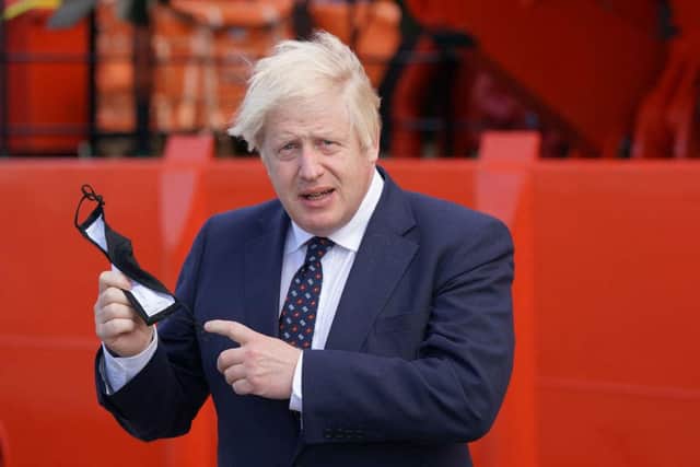 Prime Minister Boris Johnson, pictured holding his face mask, before boarding the vessel Alba at Fraserburgh Harbour, Aberdeenshire in August. Picture: Jane Barlow/POOL/AFP via Getty Images.