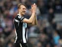 Dan Burn applauds Newcastle United fans after the final whistle.