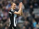Dan Burn applauds Newcastle United fans after the final whistle.