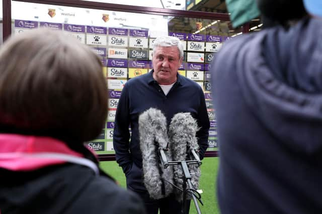 Steve Bruce speaks to rights-holding media pitchside at Vicarage Road.