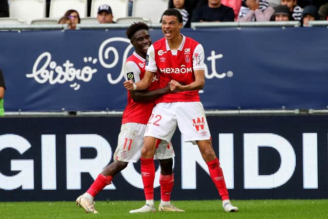 Reims' French forward Hugo Ekitike (R) celebrates after scoring during the French L1 football match between FC Girondins de Bordeaux and Stade de Reims at The Matmut Atlantique Stadium in Bordeaux, south-western France on October 31, 2021. (Photo by ROMAIN PERROCHEAU / AFP)