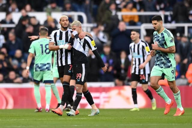 Newcastle United midfielder Bruno Guimaraes leaves the pitch in tears, consoled by Joelinton.