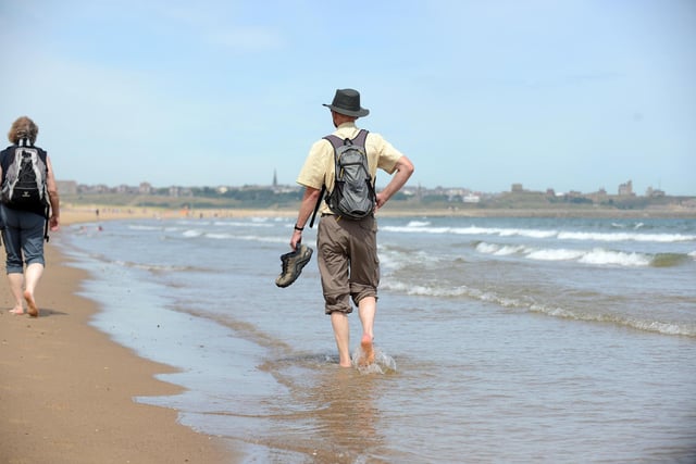 Resident walks in the sea at Sandhaven beach to cool down during the warm weather
