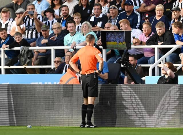 Referee Jarred Gillett checks the VAR screen of the red card given to Kieran Trippier of Newcastle United which is overturned to a yellow card during the Premier League match between Newcastle United and Manchester City at St. James Park on August 21, 2022 in Newcastle upon Tyne, England. (Photo by Stu Forster/Getty Images)