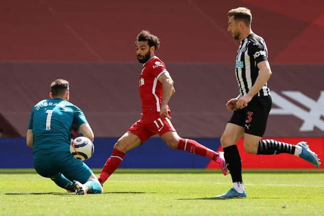 Newcastle United's Slovakian goalkeeper Martin Dubravka (L) saves a shot from Liverpool's Egyptian midfielder Mohamed Salah (C) during the English Premier League football match between Liverpool and Newcastle United at Anfield in Liverpool, north west England on April 24, 2021.