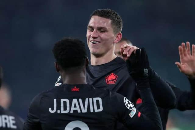 Lille's Canadian forward Jonathan David (L) celebrates scoring the 2-0 lead with Lille's Dutch defender Sven Botman during the UEFA Champions League group G football match VfL Wolfsburg v Lille LOSC in Wolfsburg, northern Germany on December 8, 2021. (Photo by Ronny Hartmann / AFP) (Photo by RONNY HARTMANN/AFP via Getty Images)