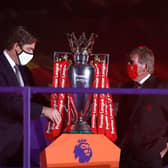LIVERPOOL, ENGLAND - JULY 22: Richard Masters, Chief Executive of Premier League and Sir Kenny Dalglish, Former Captain and Manager of Liverpool place The Premier League trophy upon a plinth following the Premier League match between Liverpool FC and Chelsea FC at Anfield on July 22, 2020 in Liverpool, England.