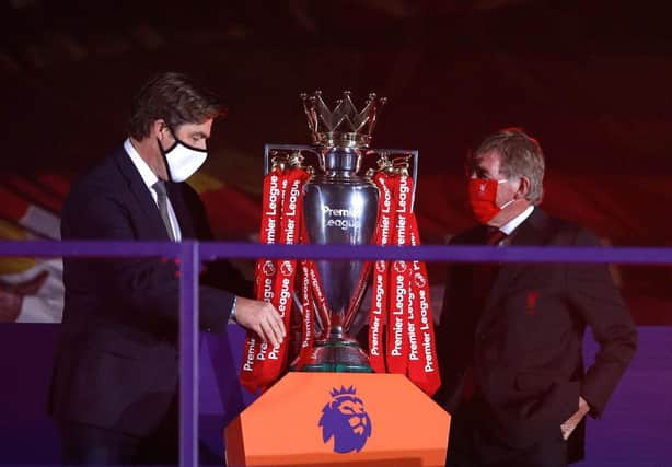 LIVERPOOL, ENGLAND - JULY 22: Richard Masters, Chief Executive of Premier League and Sir Kenny Dalglish, Former Captain and Manager of Liverpool place The Premier League trophy upon a plinth following the Premier League match between Liverpool FC and Chelsea FC at Anfield on July 22, 2020 in Liverpool, England.