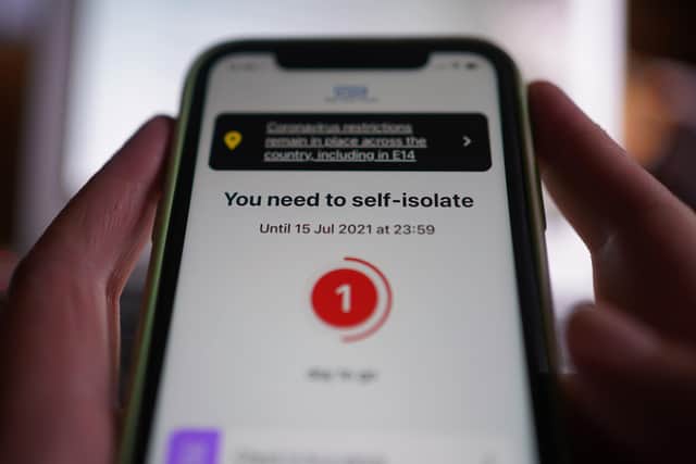 A message to self-isolate, with one day of required isolation remaining, is displayed on the NHS coronavirus contact tracing app on a mobile phone, in London. Picture date: Thursday July 15, 2021. PA Photo. See PA story HEALTH Coronavirus.