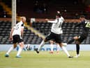 Joe Willock of Newcastle United scores their sides first goal whilst under pressure from Tosin Adarabioyo of Fulham during the Premier League match between Fulham and Newcastle United at Craven Cottage on May 23, 2021 in London, England.