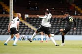 Joe Willock of Newcastle United scores their sides first goal whilst under pressure from Tosin Adarabioyo of Fulham during the Premier League match between Fulham and Newcastle United at Craven Cottage on May 23, 2021 in London, England.