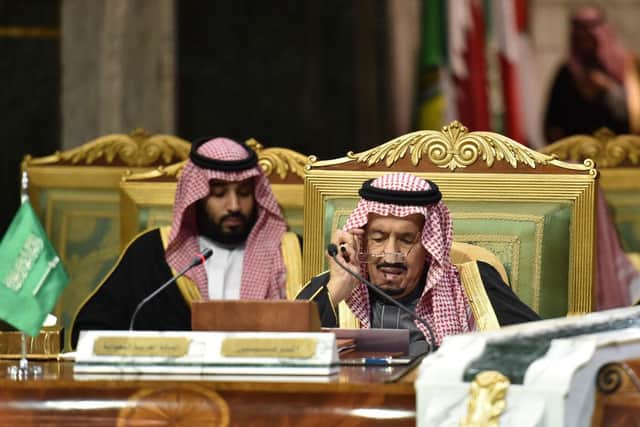 Saudi King Salman bin Abdulaziz (R), flanked by his son Crown Prince Mohammed bin Salman (L), puts on his spectacles as he prepares to read a document while chairing a session of the 40th Gulf Cooperation Council (GCC) summit held at the Saudi capital Riyadh on December 10, 2019. (Photo by Fayez Nureldine / AFP) (Photo by FAYEZ NURELDINE/AFP via Getty Images)