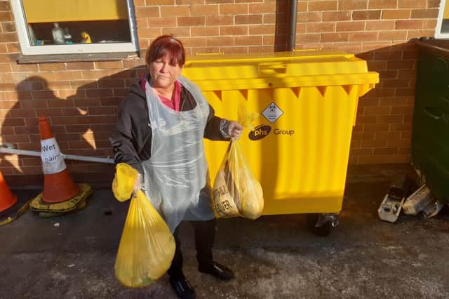 Nursery practitioner Marie Gibson alongside the specialist clinical waste disposal bin which the nursery pays for.