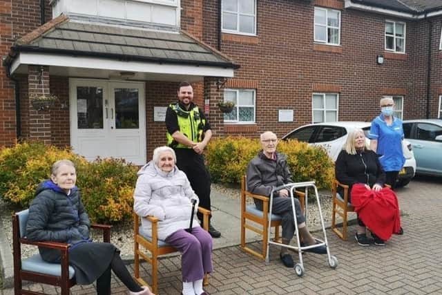 (sat, from left) Willowdene Care Home residents Barbara Berry, 81, Margaret Branch, 90, Henry Tweddle, 85, and Cheryl Cook, (64), with (standing) traffic officer Thomas Wade and lead senior carer at the home Sharon Dobson.