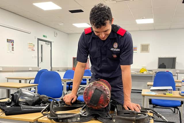 New recruit Toby Holway, 28, learning about some of the breathing apparatus used by firefighters.
