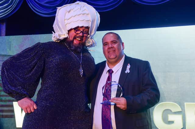 Fundraiser of the Year Wayne Groves receives his trophy from 'Big Pink Dress' Colin Burgin-Plews.