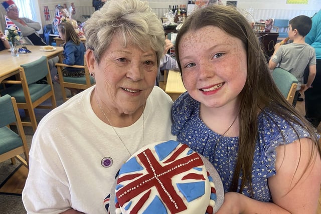 Lilian Porter with her great-granddaughter Jessica Haslam, holding the Jubilee cake they made and will raffle to raise funds for the centre at Jubilee Court.