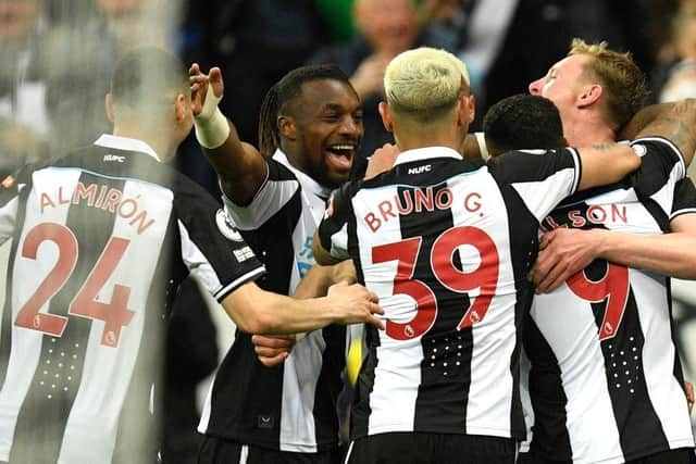 Newcastle United's English striker Callum Wilson is mobbed by teammates after scoring the opening goal during the English Premier League football match between Newcastle United and Arsenal at St James' Park in Newcastle-upon-Tyne, north east England on May 16, 2022. (Photo by OLI SCARFF/AFP via Getty Images)