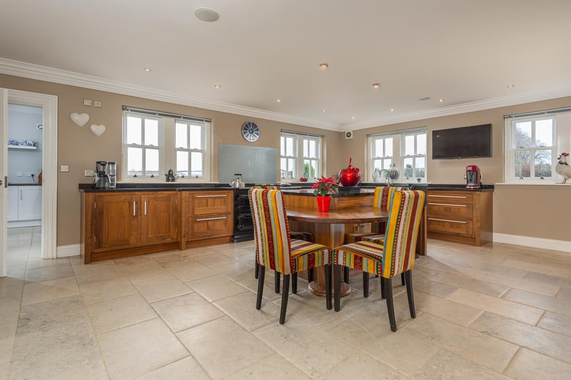 The spacious kitchen provides a full range of wall and base units and central island with granite worktops, Aga oven and a range of modern integrated appliances.