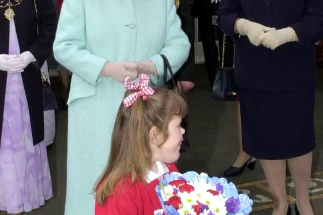File photo dated 7/5/2002 of Katie Meehan, presenting Queen Elizabeth II with flowers during her visit to St Josephs RC Primary School, Jarrow, Tyne and Wear. The British social media influencer whose meeting with the Queen aged six made newspaper headlines 20 years ago has said the "wholesome and wonderful experience" showed her she "can do anything". Picture date: Friday September 9, 2022.