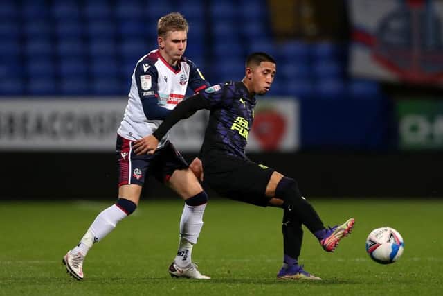 Rodrigo Vilca of Newcastle United U21's on the ball with Jak Hickman of Bolton Wanderers during the EFL Trophy match between Bolton Wanderers and Newcastle United U21 at University of Bolton Stadium on November 17, 2020 in Bolton, England. Sporting stadiums around the UK remain under strict restrictions due to the Coronavirus Pandemic as Government social distancing laws prohibit fans inside venues resulting in games being played behind closed doors. (Photo by Charlotte Tattersall/Getty Images)