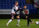 Rodrigo Vilca of Newcastle United U21's on the ball with Jak Hickman of Bolton Wanderers during the EFL Trophy match between Bolton Wanderers and Newcastle United U21 at University of Bolton Stadium on November 17, 2020 in Bolton, England. Sporting stadiums around the UK remain under strict restrictions due to the Coronavirus Pandemic as Government social distancing laws prohibit fans inside venues resulting in games being played behind closed doors. (Photo by Charlotte Tattersall/Getty Images)