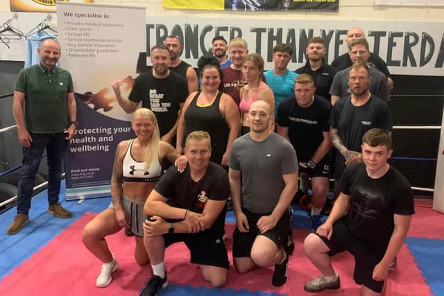 Coaches and gym members celebrate hitting raising £250k for charities through boxing shows and other charity events including the David Goggins 4x4x48 challenge with Chris Goodall (front left).