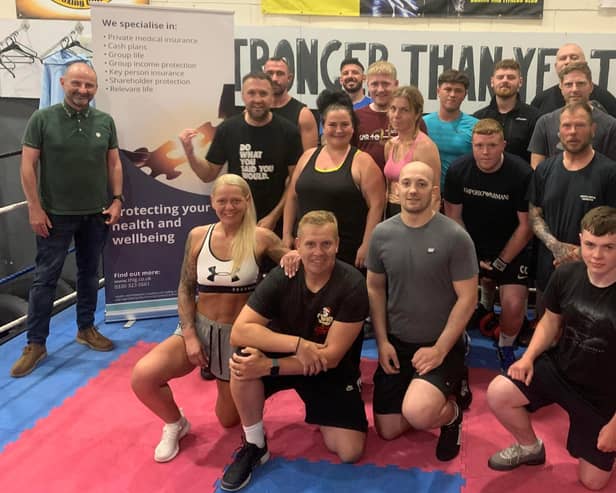 Coaches and gym members celebrate hitting raising £250k for charities through boxing shows and other charity events including the David Goggins 4x4x48 challenge with Chris Goodall (front left).