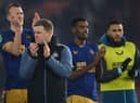 Newcastle United head coach Eddie Howe and some of his players, including Alexander Isak, applaud fans at the end of the game.