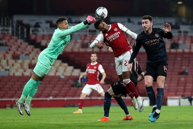 Zack Steffen of Manchester City punches the ball away from Joe Willock of Arsenal.