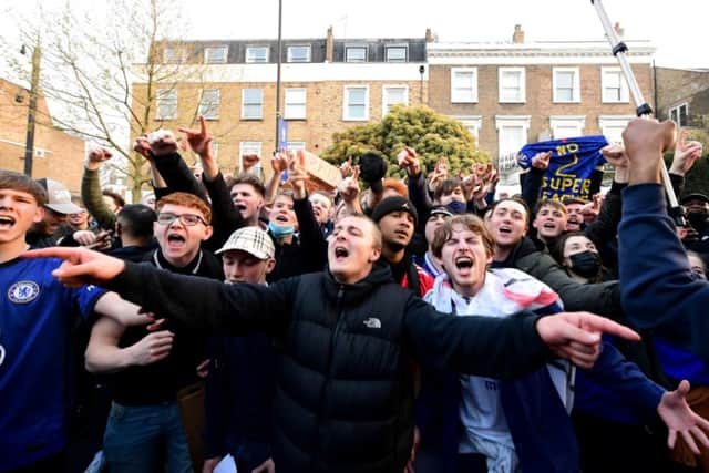 Fans react after first hearing Chelsea was preparing to withdraw from the Super League, outside Stamford Bridge, London.