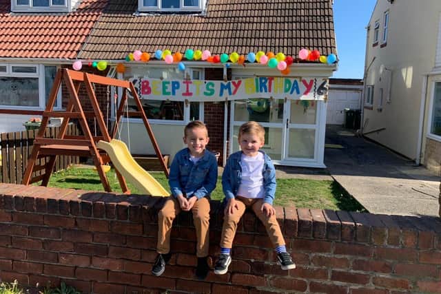 Grayson and his younger brother Drew, celebrate outside their home.