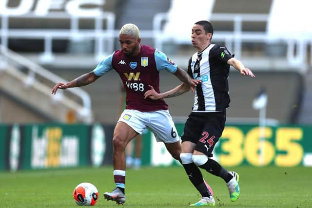 Aston Villa's Douglas Luiz of and Newcastle's Miguel Almiron challenge for the ball.