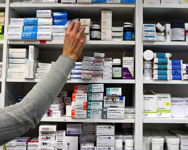 A pharmacist stocks shelves at a chemist. PIC: Julien Behal/PA Wire