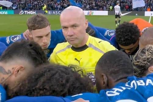 Wigan referee Paul Tierney gets up close and personal with the Chelsea team.