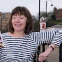 Author Glenda Young on South Bay beach with her first book Murder at the Seaview Hotel which has been nominated for an award