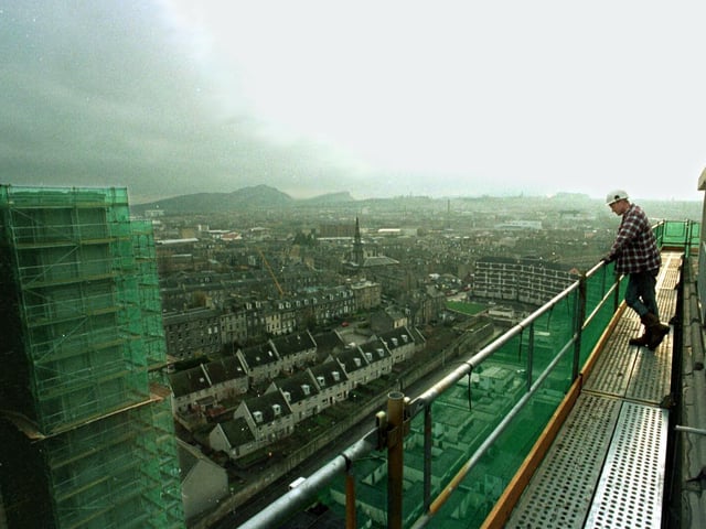 Demolition expert Rob Morgan makes the most of the dramatic view of the capital from his 210 foot high scaffold vantage point on about-to-be-demolished high rises Cairngorm House and Grampian House in Leith. Picture taken in 1997.