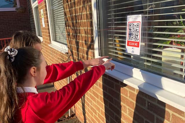 Children from St Joseph's Catholic Primary School with one of the QR codes.