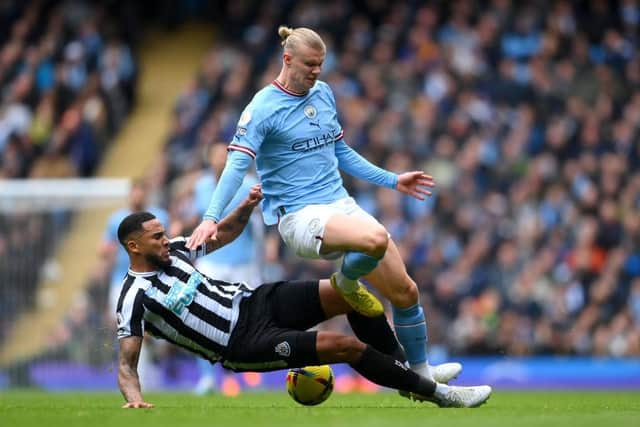 MANCHESTER, ENGLAND - MARCH 04: Erling Haaland of Manchester City is tackled by Jamaal Lascelles of Newcastle United during the Premier League match between Manchester City and Newcastle United at Etihad Stadium on March 04, 2023 in Manchester, England. (Photo by Laurence Griffiths/Getty Images)