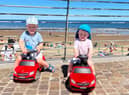 Elijah and Tommy driving their cars