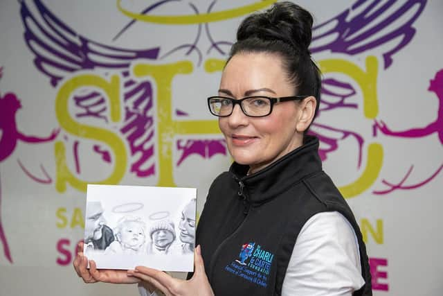 Sarah Cookson holding a picture of her husband Chris Cookson MBE, and their children Charlie and Carter after whom the Foundation is named.