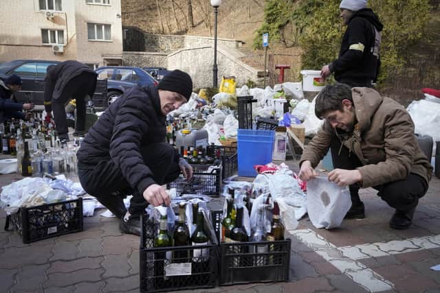 Members of civil defense prepare Molotov cocktails in a yard in Kyiv, Ukraine, Sunday, Feb. 27, 2022. (AP Photo/Efrem Lukatsky)