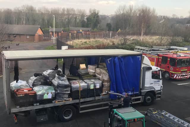 Staff at Tony Carter Transport Limited loading fire equipment onto lorry at TWFRS Stores warehouse