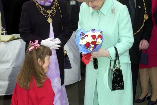 File photo dated 7/5/2002 of Katie Meehan, presenting Queen Elizabeth II with flowers during her visit to St Josephs RC Primary School, Jarrow, Tyne and Wear. The British social media influencer whose meeting with the Queen aged six made newspaper headlines 20 years ago has said the "wholesome and wonderful experience" showed her she "can do anything". Picture date: Friday September 9, 2022.