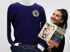 Auctioneer Amy Cameron with Jim Baxter's match worn jersey from Scotland's 3-2 win over then world champions, England, at Wembley in 1967.
