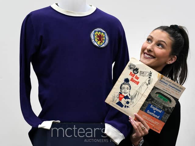 Auctioneer Amy Cameron with Jim Baxter's match worn jersey from Scotland's 3-2 win over then world champions, England, at Wembley in 1967.