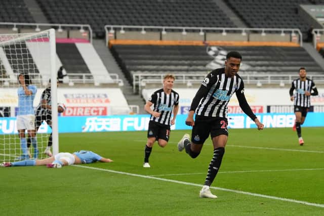 Joe Willock of Newcastle United celebrates after scoring their sides third goal, missing from the penalty spot but scoring the rebound during the Premier League match between Newcastle United and Manchester City at St. James Park on May 14, 2021 in Newcastle upon Tyne, England.