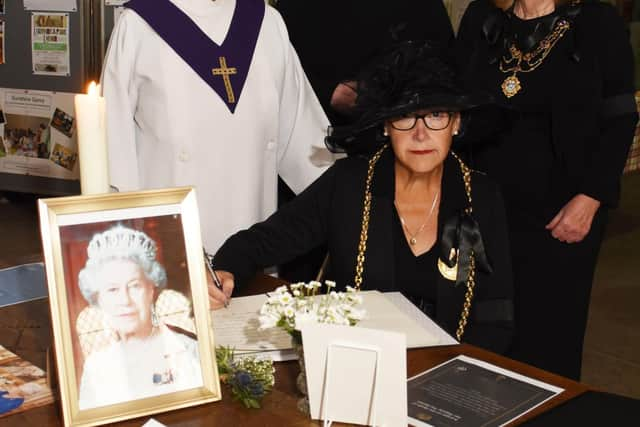 Mayor Councillor Pat Hay signs book of condolence with, from left pastoral assistant Jacki Dunn, Rev Stuart Hill and Mayoress Jean Copp.