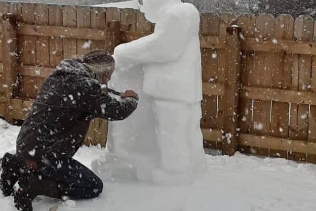 Reg Warnes carving the Captain Tom snowman.